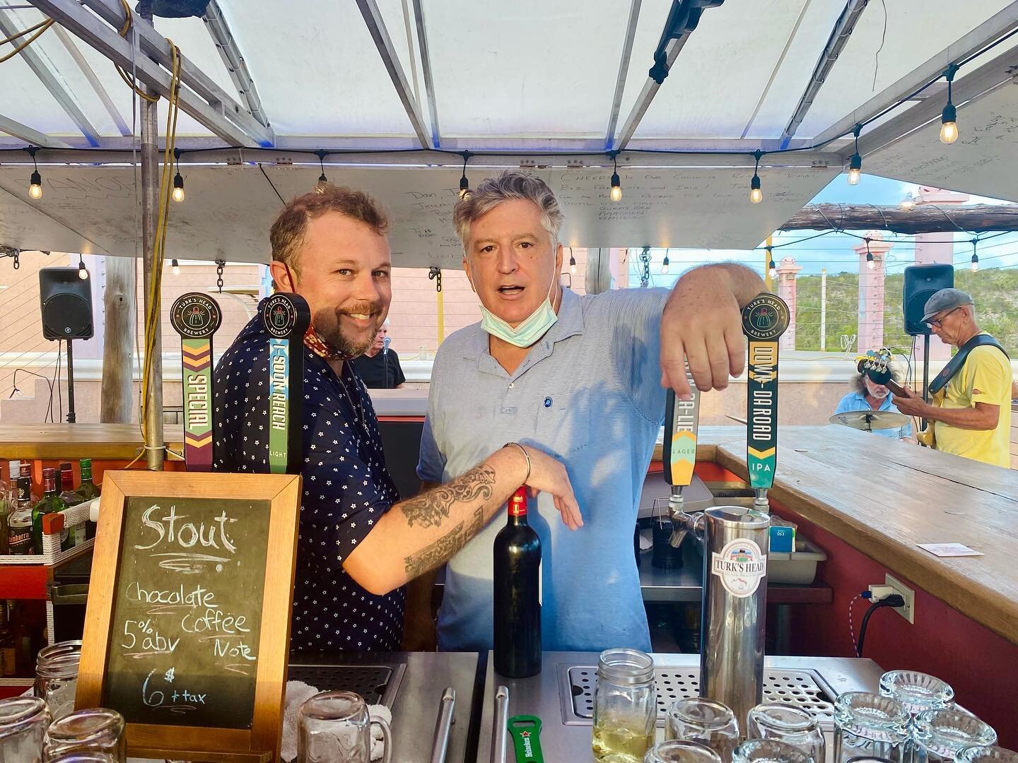 two men standing behind a bar