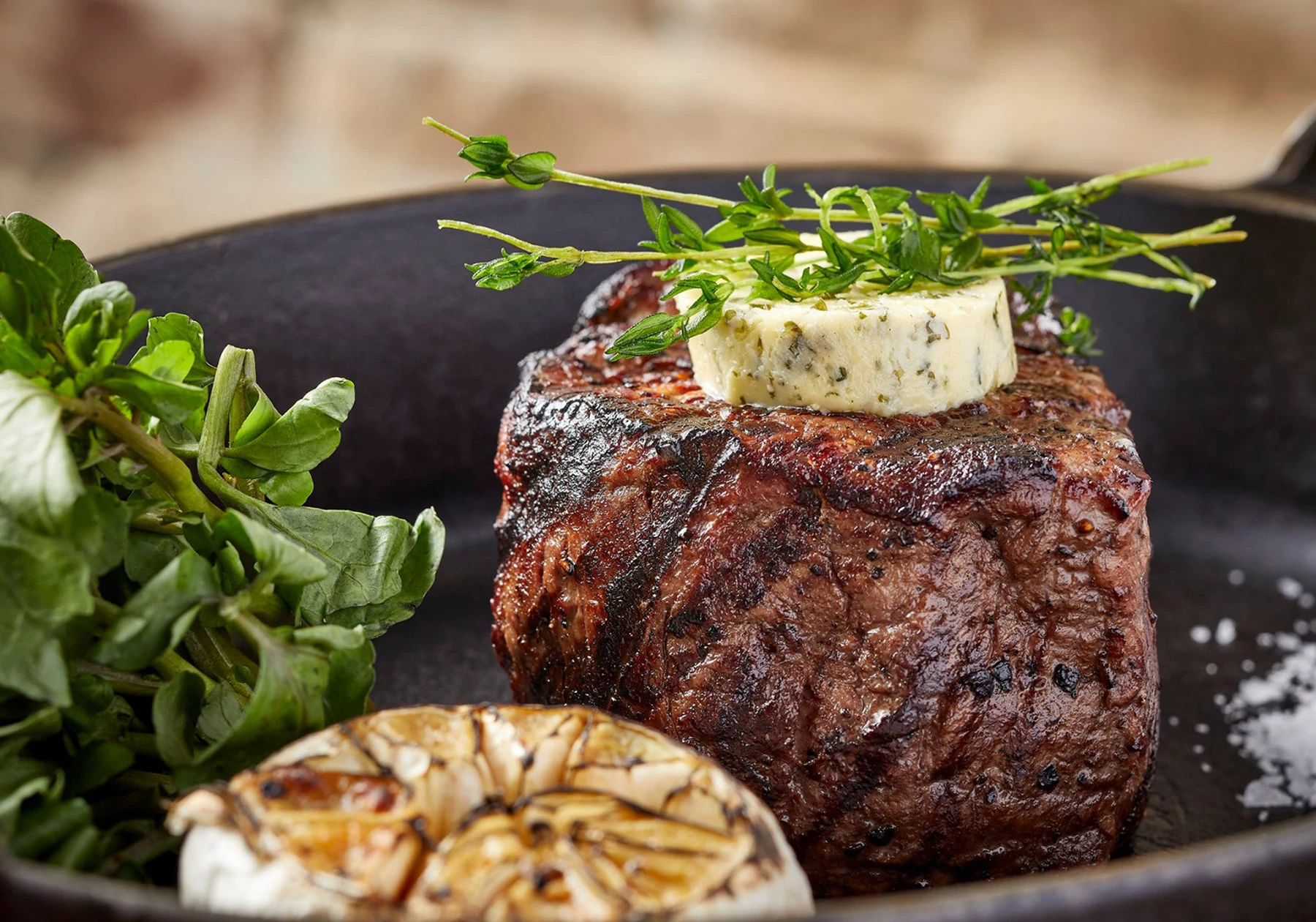 a plate of food with a piece of meat and herbs
