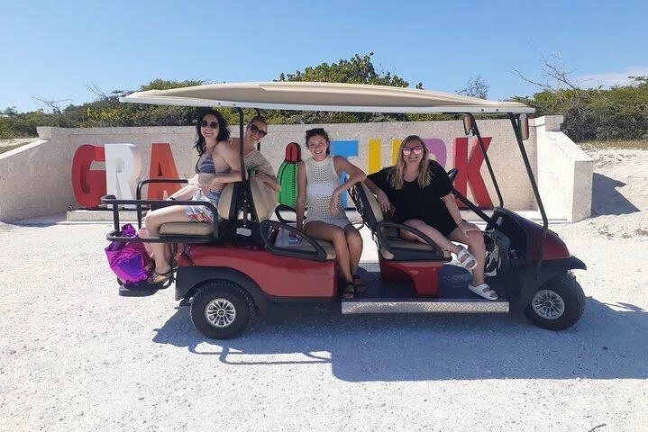 a group of women sitting in a golf cart