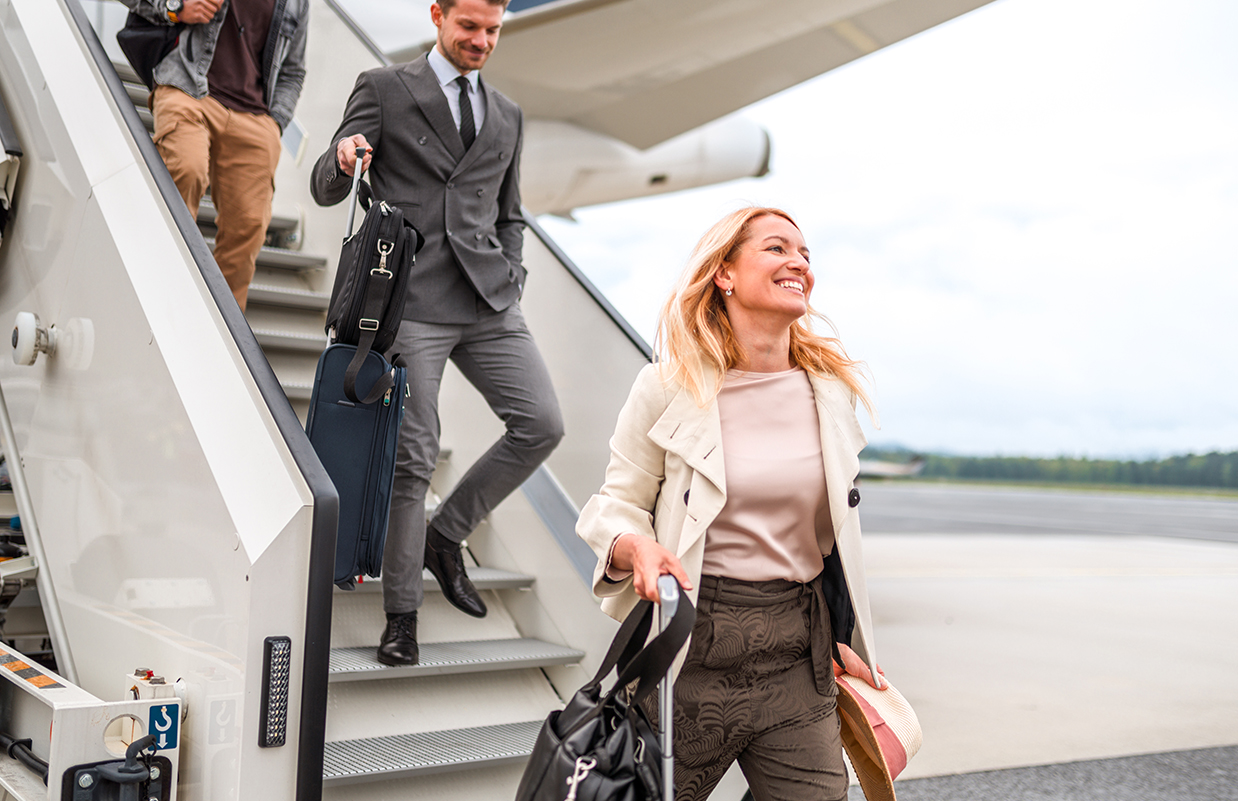 a man and woman walking down stairs with luggage