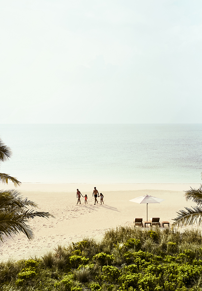 a group of people walking on a beach