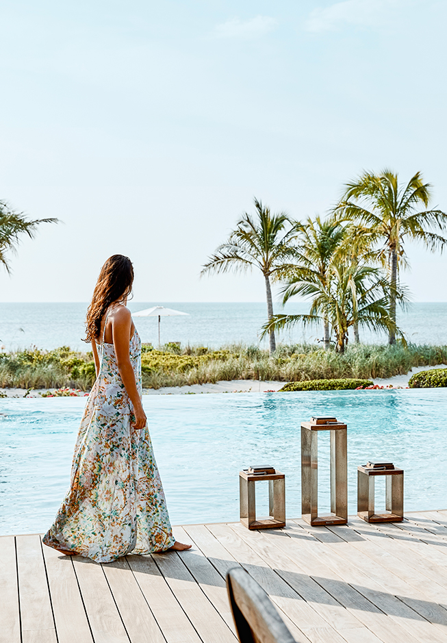 a woman in a dress by a pool