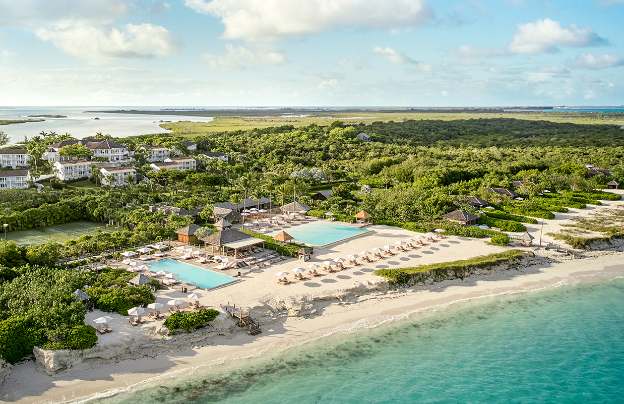 a beach with a pool and a group of buildings