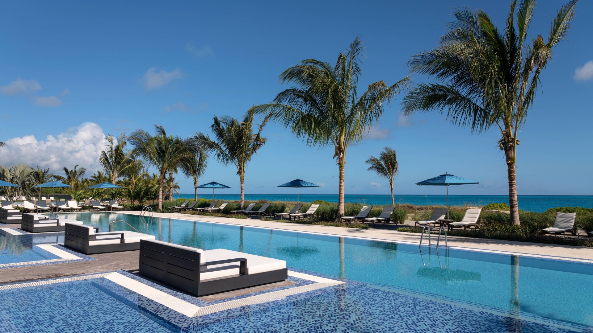 a pool with lounge chairs and umbrellas