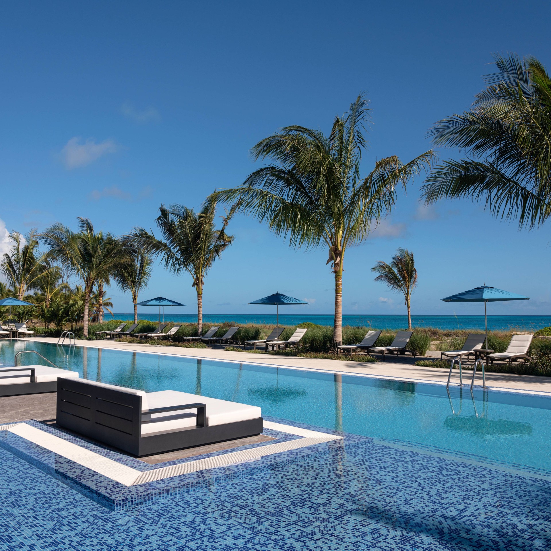 a pool with lounge chairs and umbrellas
