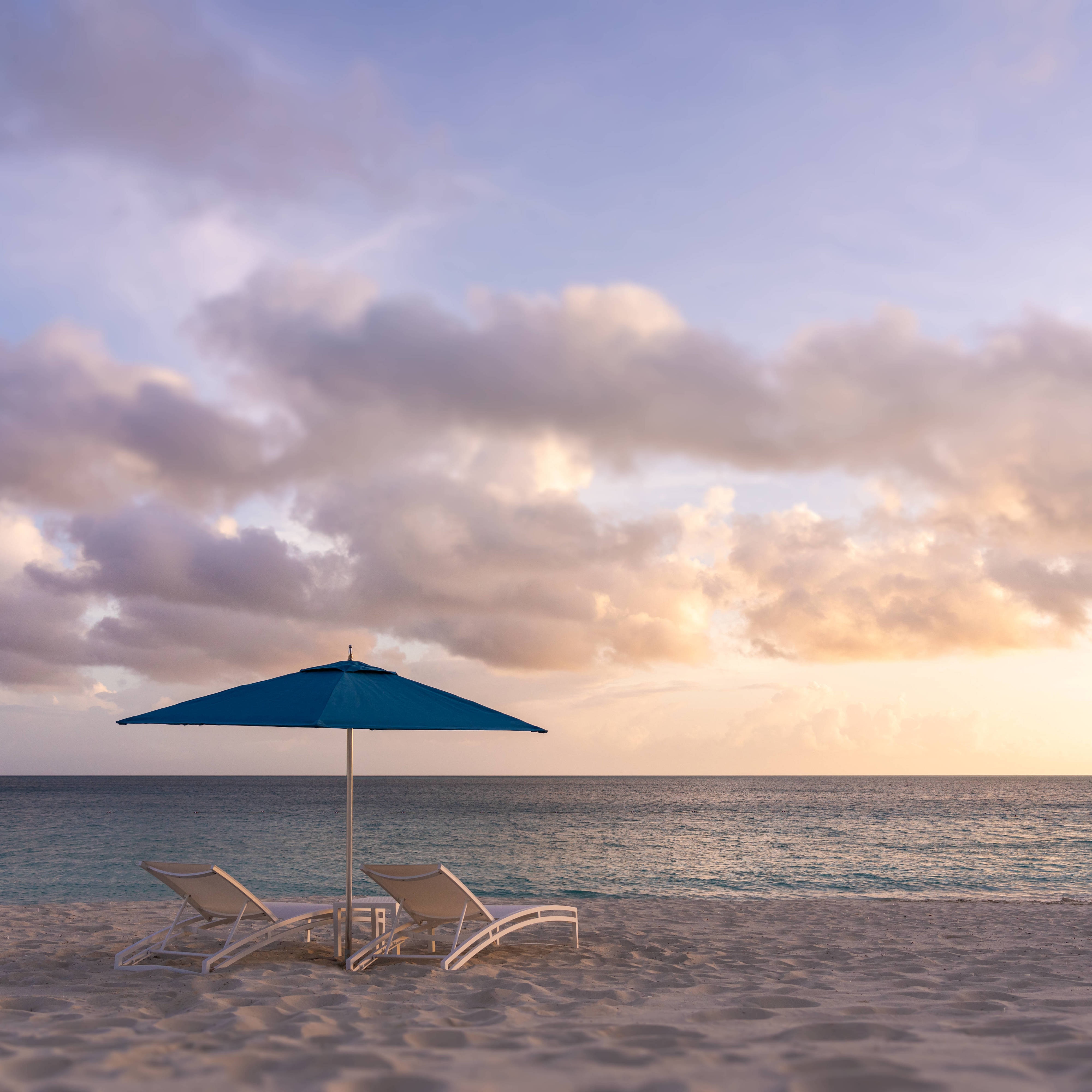 two chairs and umbrella on a beach