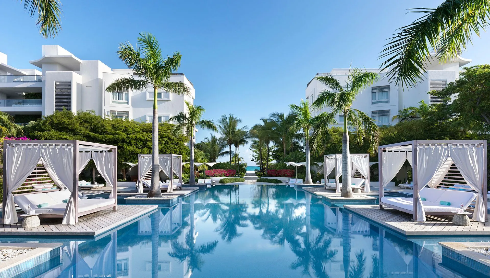 a swimming pool with white buildings and palm trees