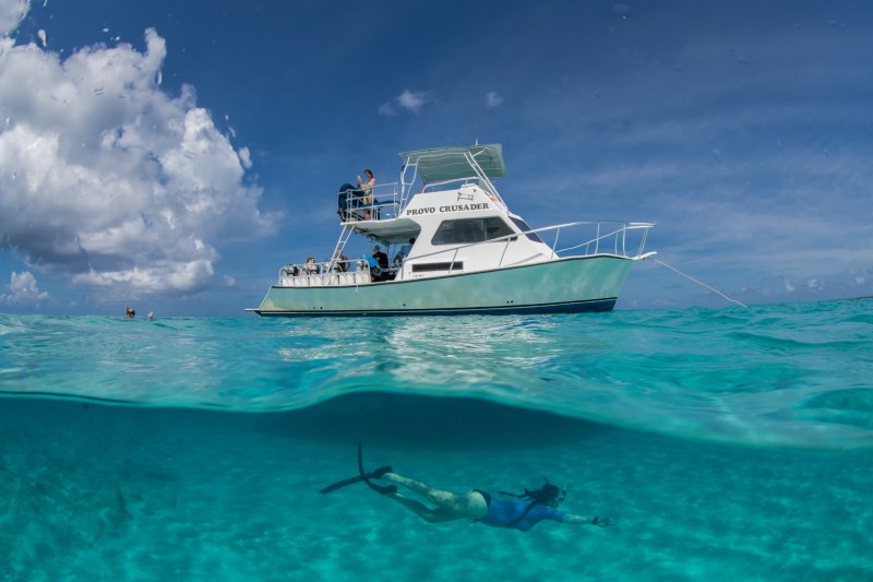 a person swimming in the water with a boat