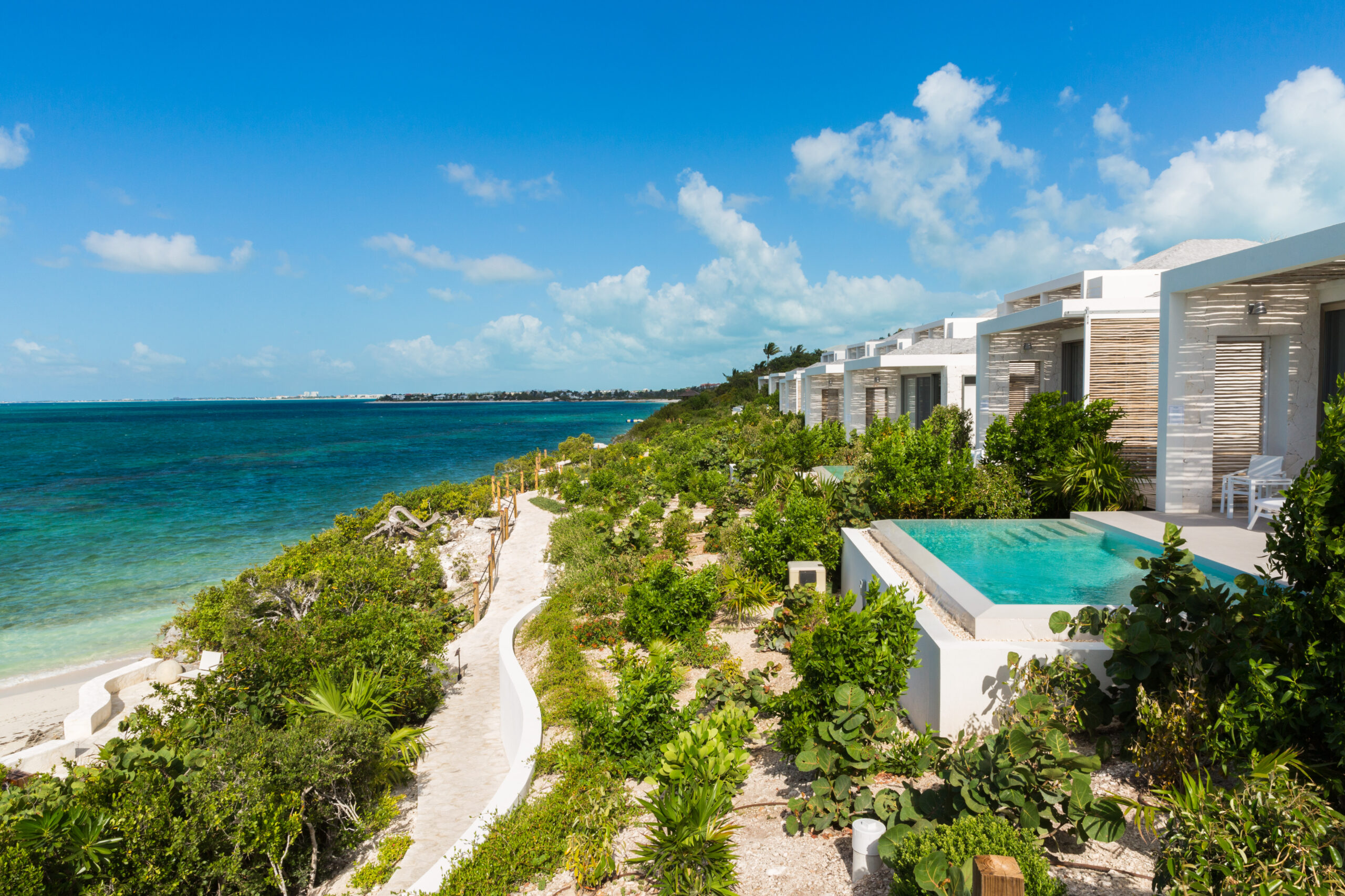 a beach with a pool and a body of water