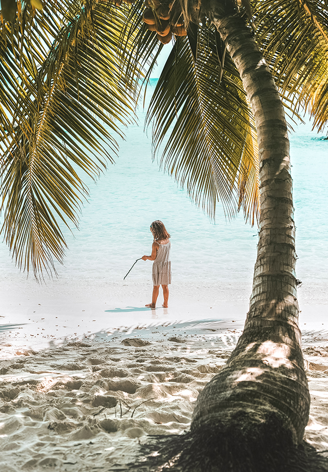 a woman standing on a beach with a stick