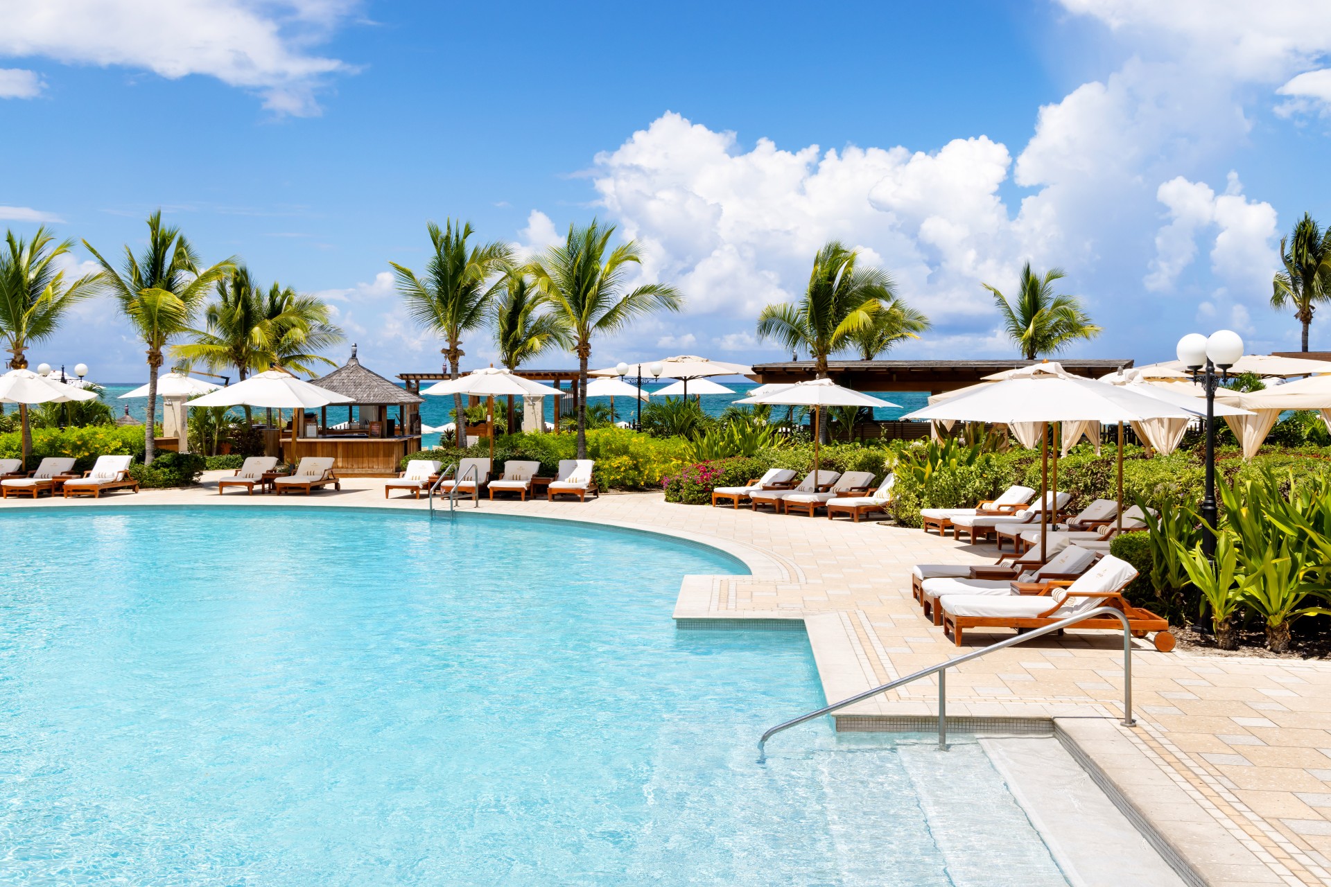 a pool with lounge chairs and umbrellas