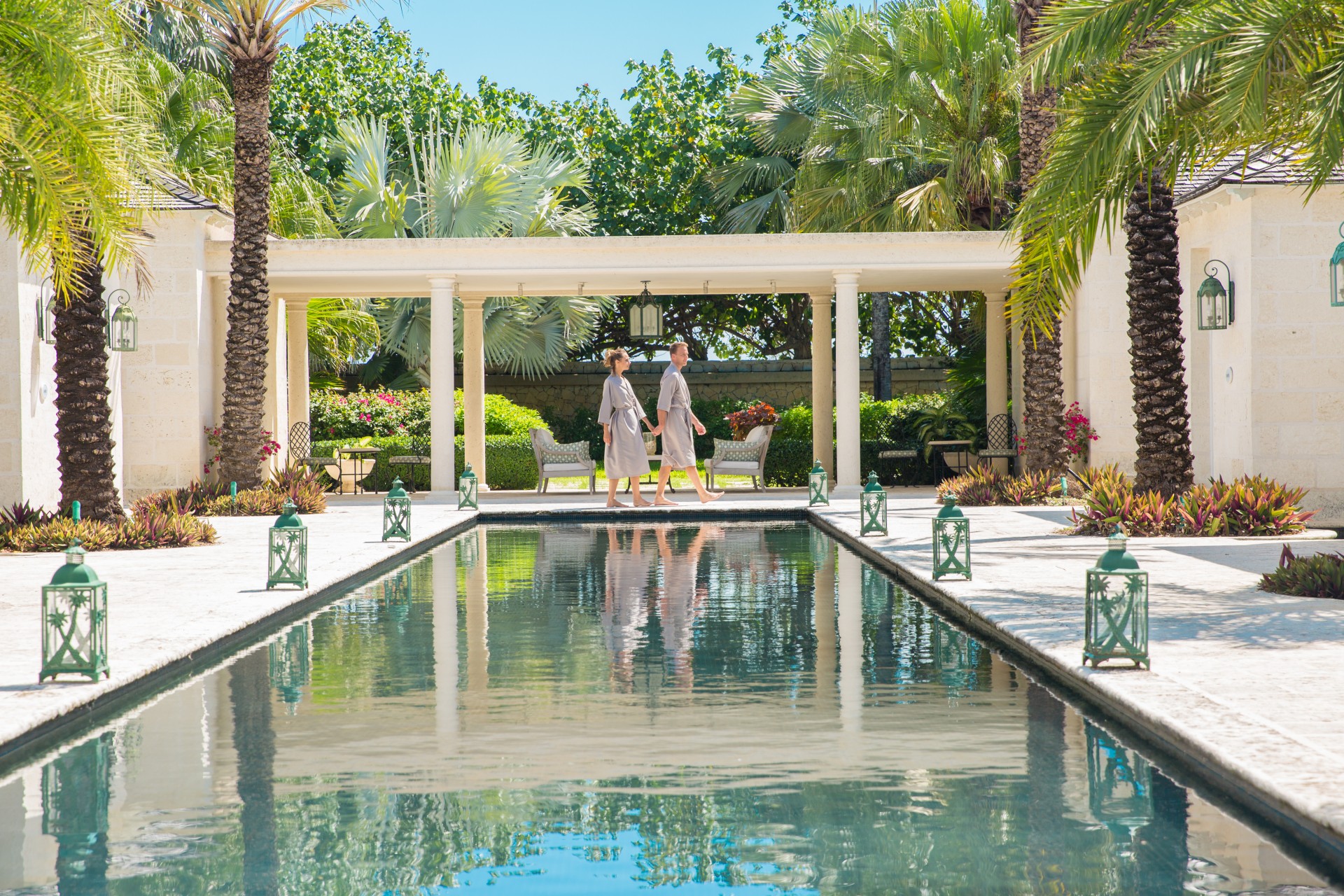 a couple of people standing next to a pool