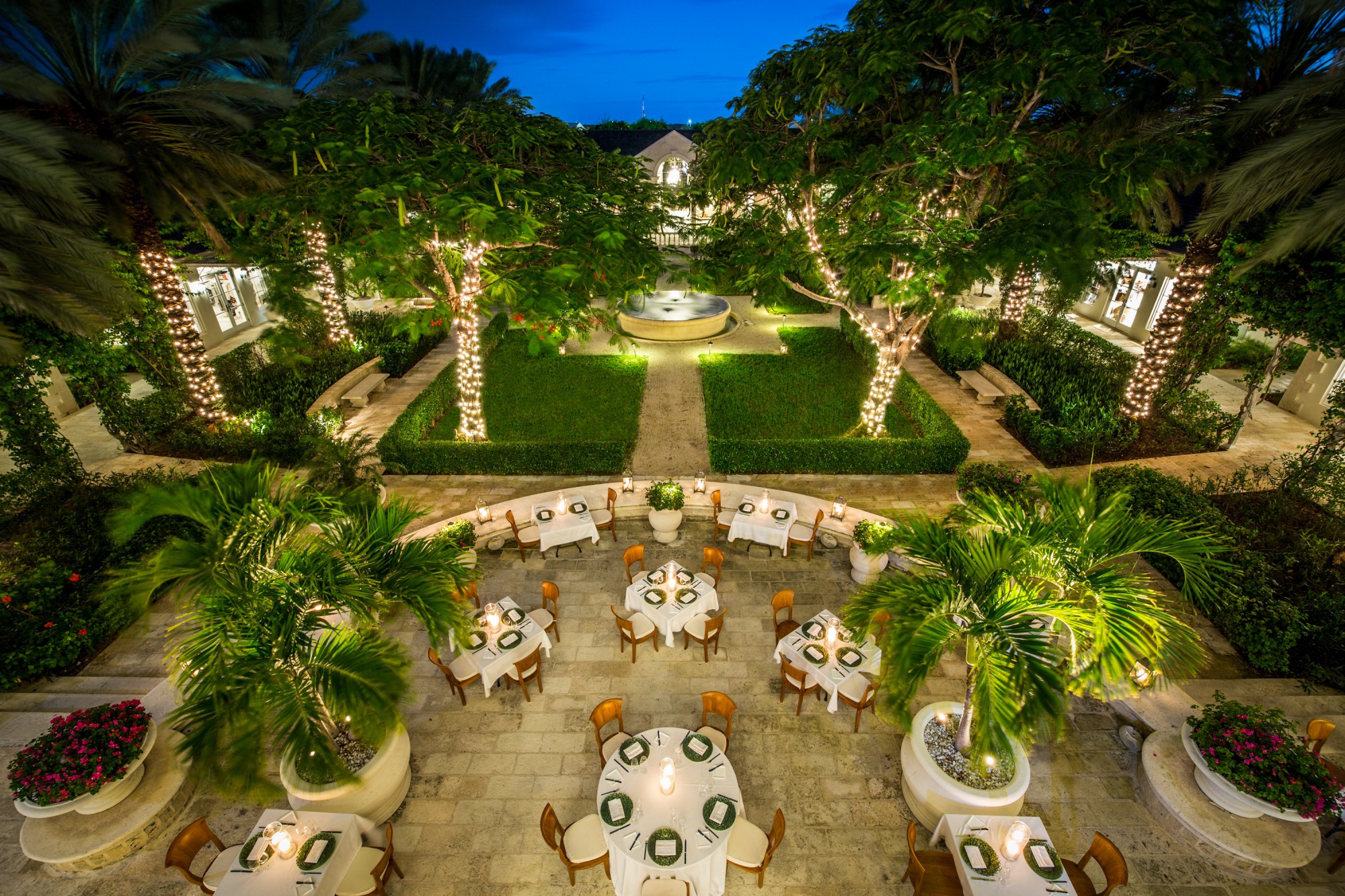 a courtyard with tables and chairs and trees