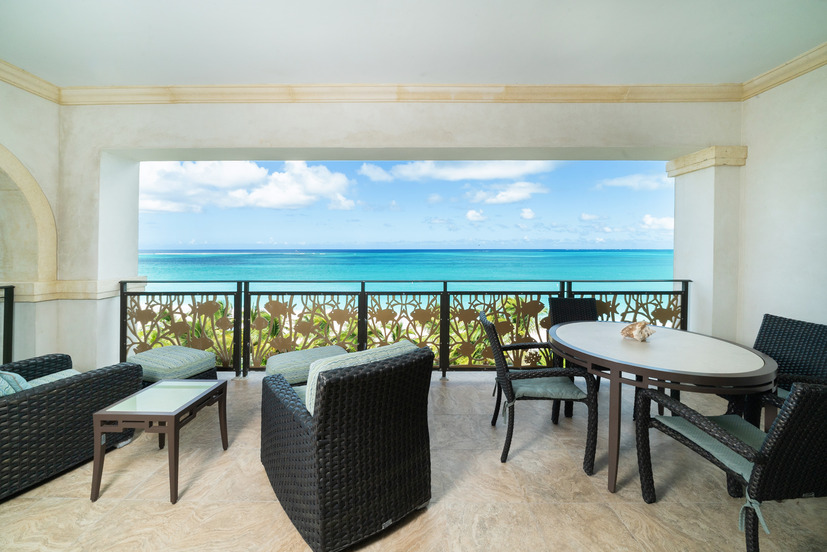a patio with chairs and a table overlooking the ocean