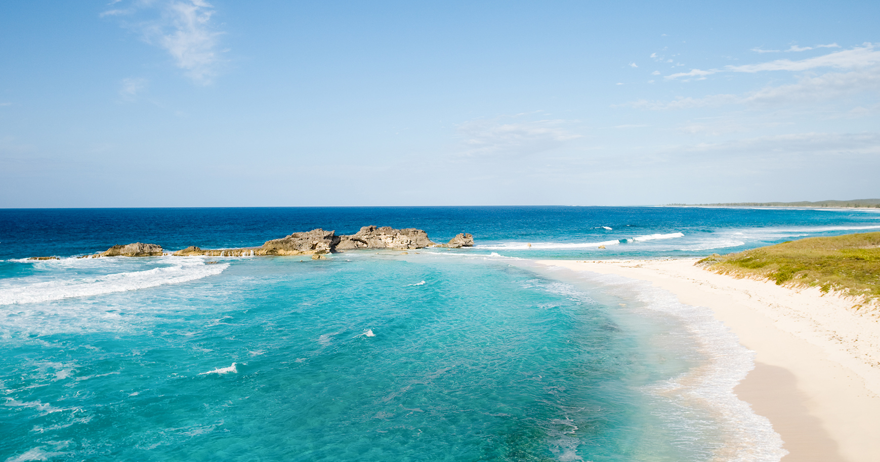 a beach with a sandy beach and blue water