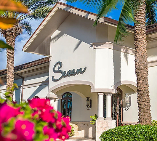 a building with palm trees and flowers