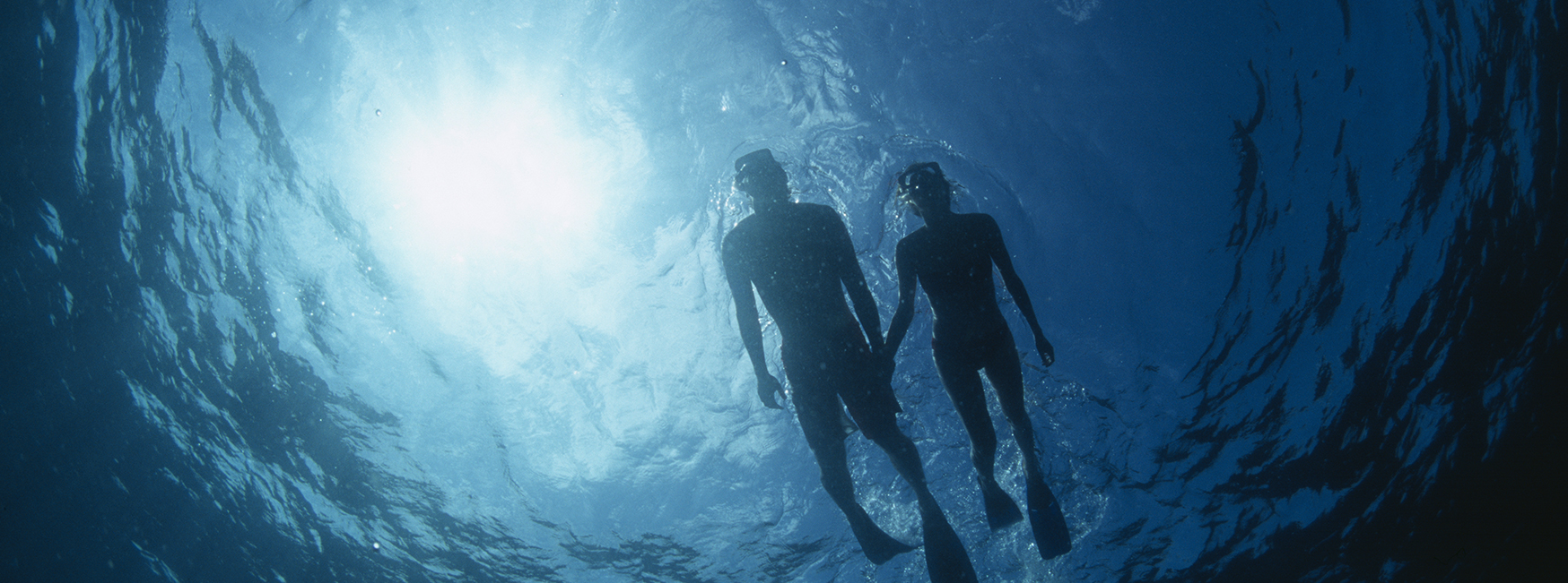 a couple of people swimming underwater