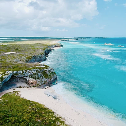 a beach with a cliff and a body of water