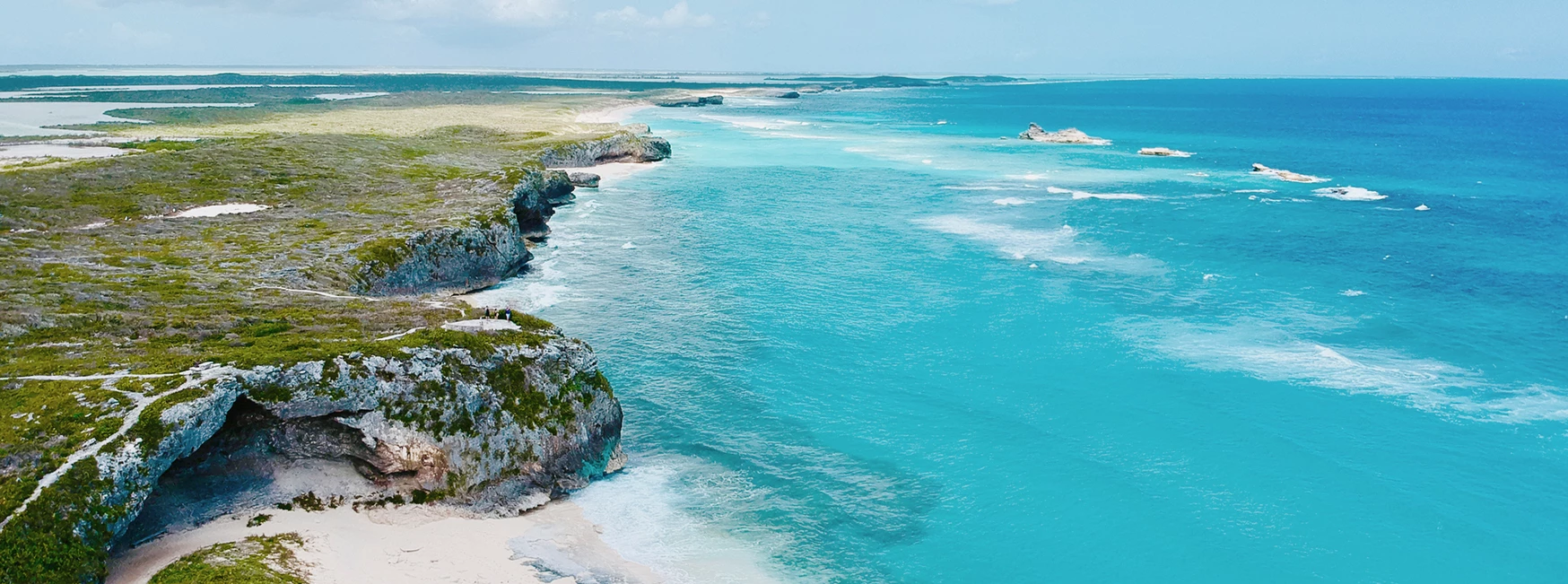 a rocky beach with blue water and land