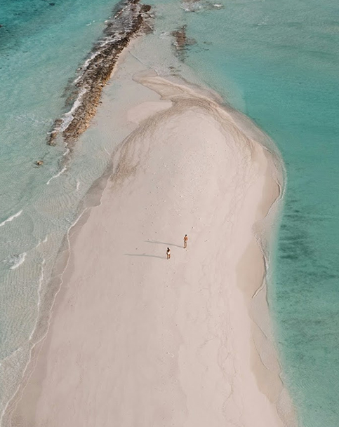 people standing on a sandy beach