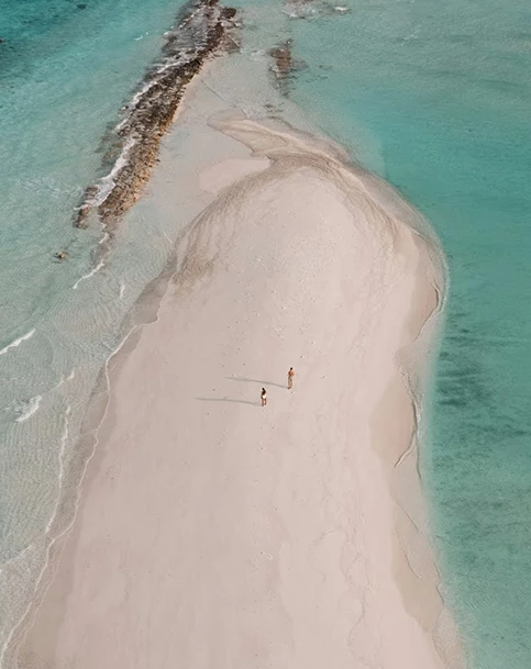 people standing on a sandy beach