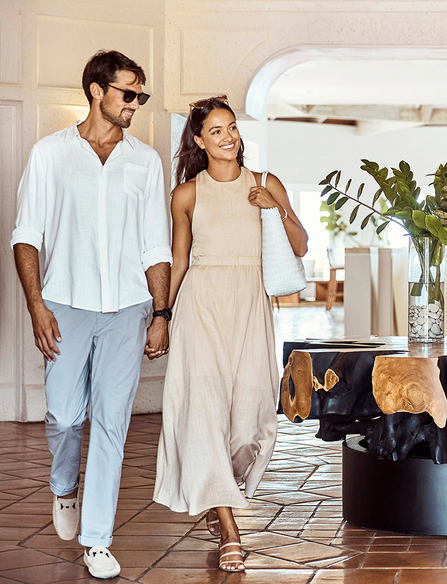 a man and woman holding hands and walking