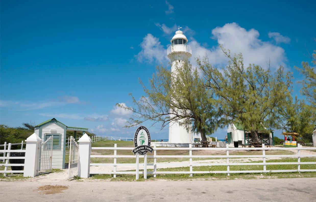 a white lighthouse with a fence and trees