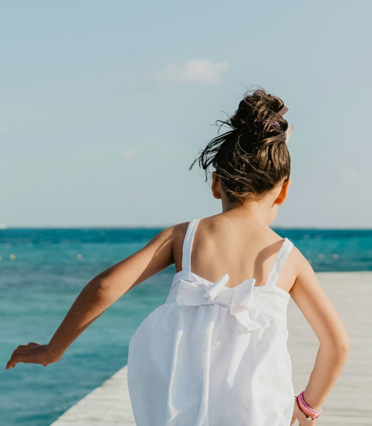 a girl in a white dress on a dock
