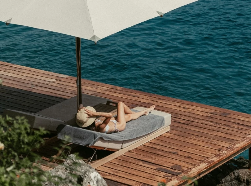 a woman lying on a deck by the water