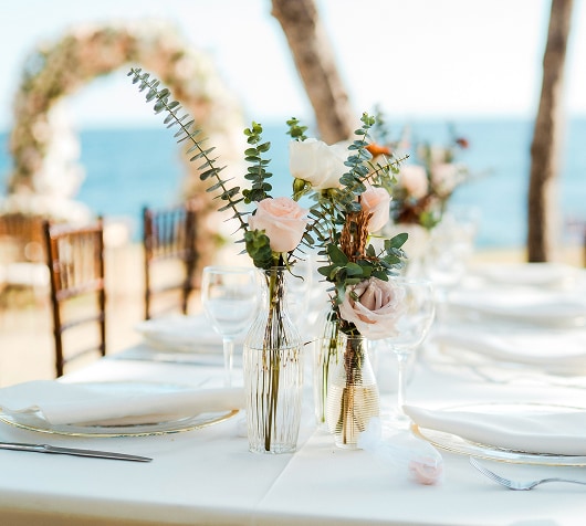 a table set with flowers and glasses on it
