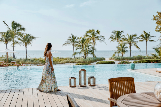 a woman in a dress by a pool