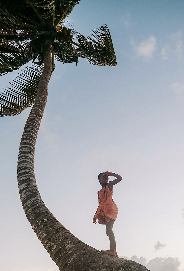 a woman standing on a palm tree