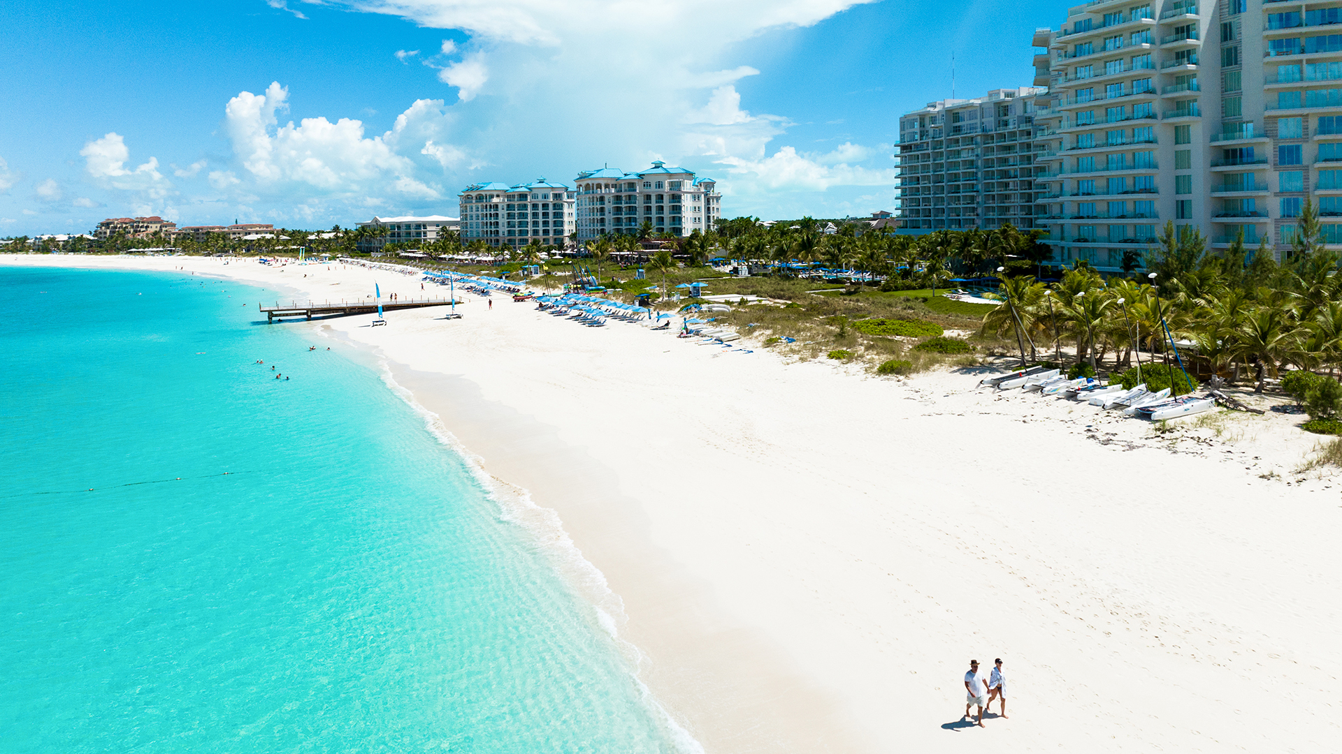 a beach with people walking on it