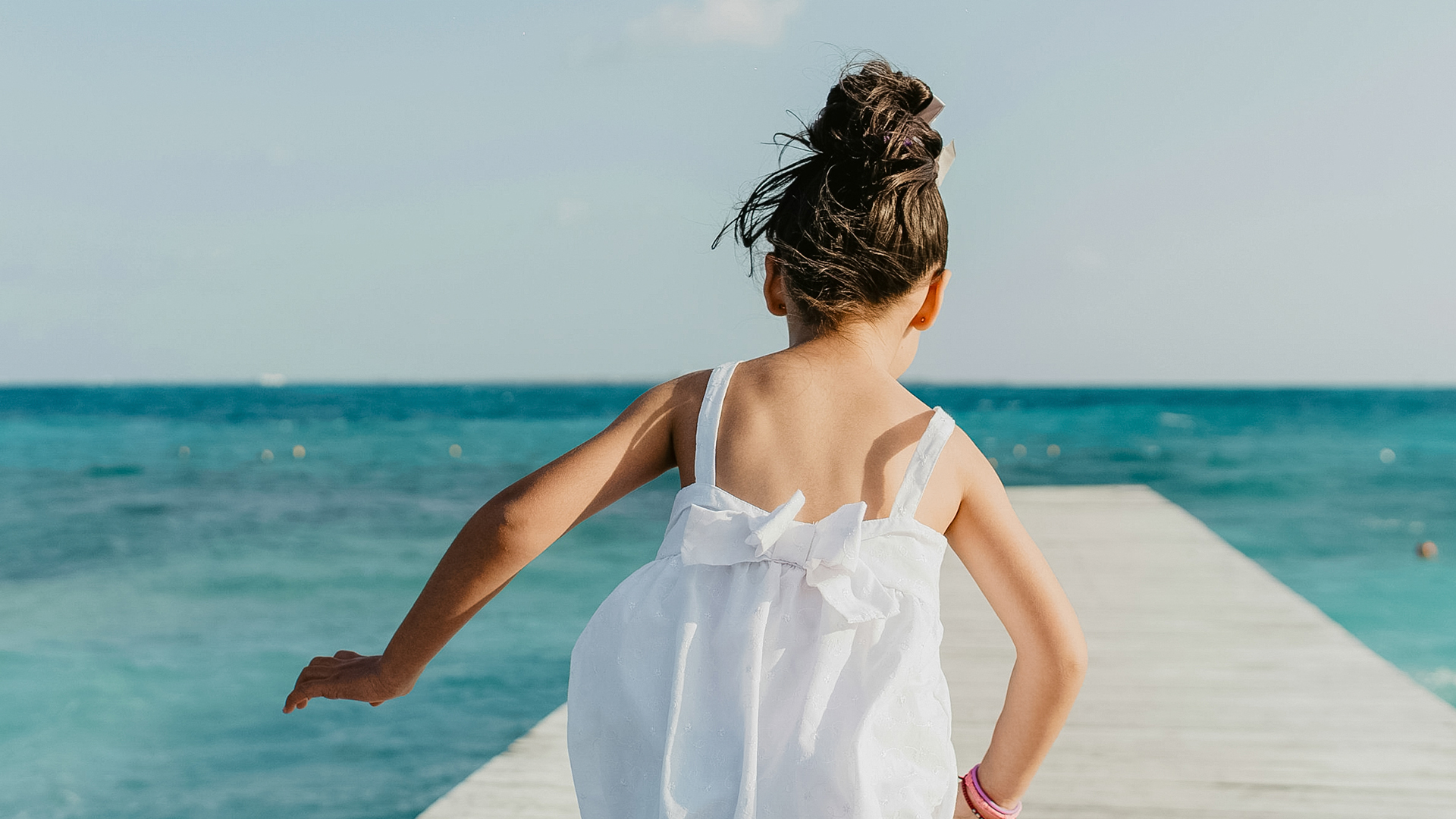 a girl in a white dress on a dock