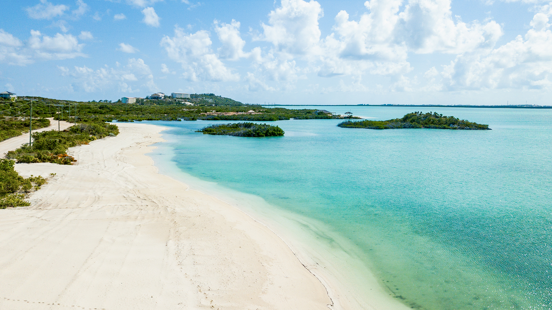 a beach with land and blue water