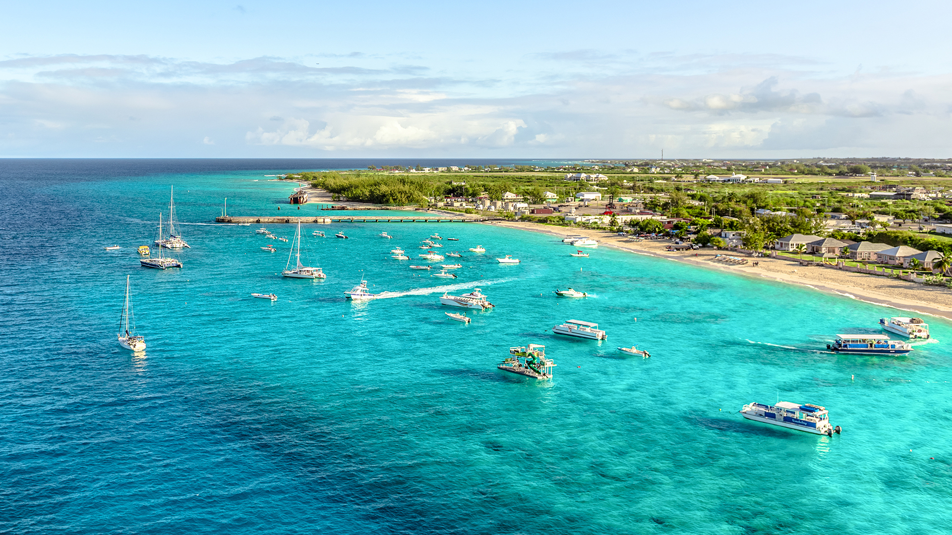 boats in a body of water with boats and a beach