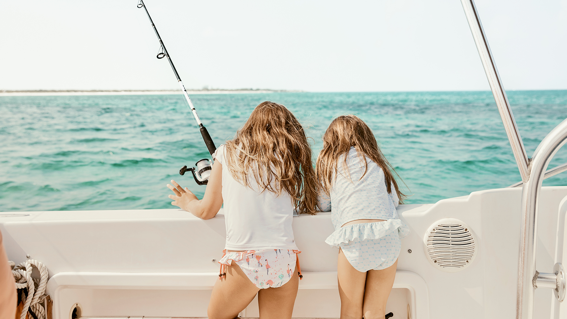 two girls on a boat with a fishing pole