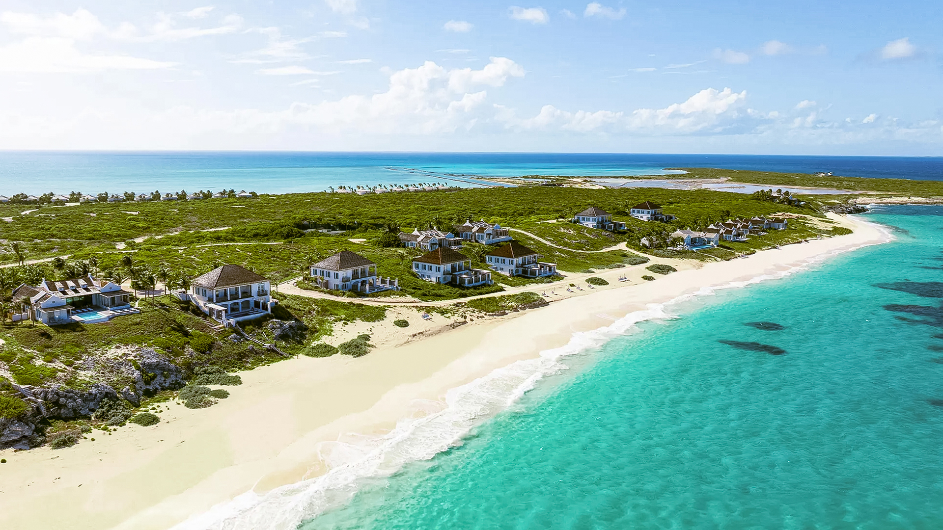 a beach with houses and a body of water