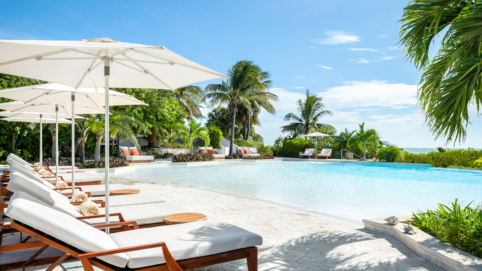 a pool with lounge chairs and umbrellas