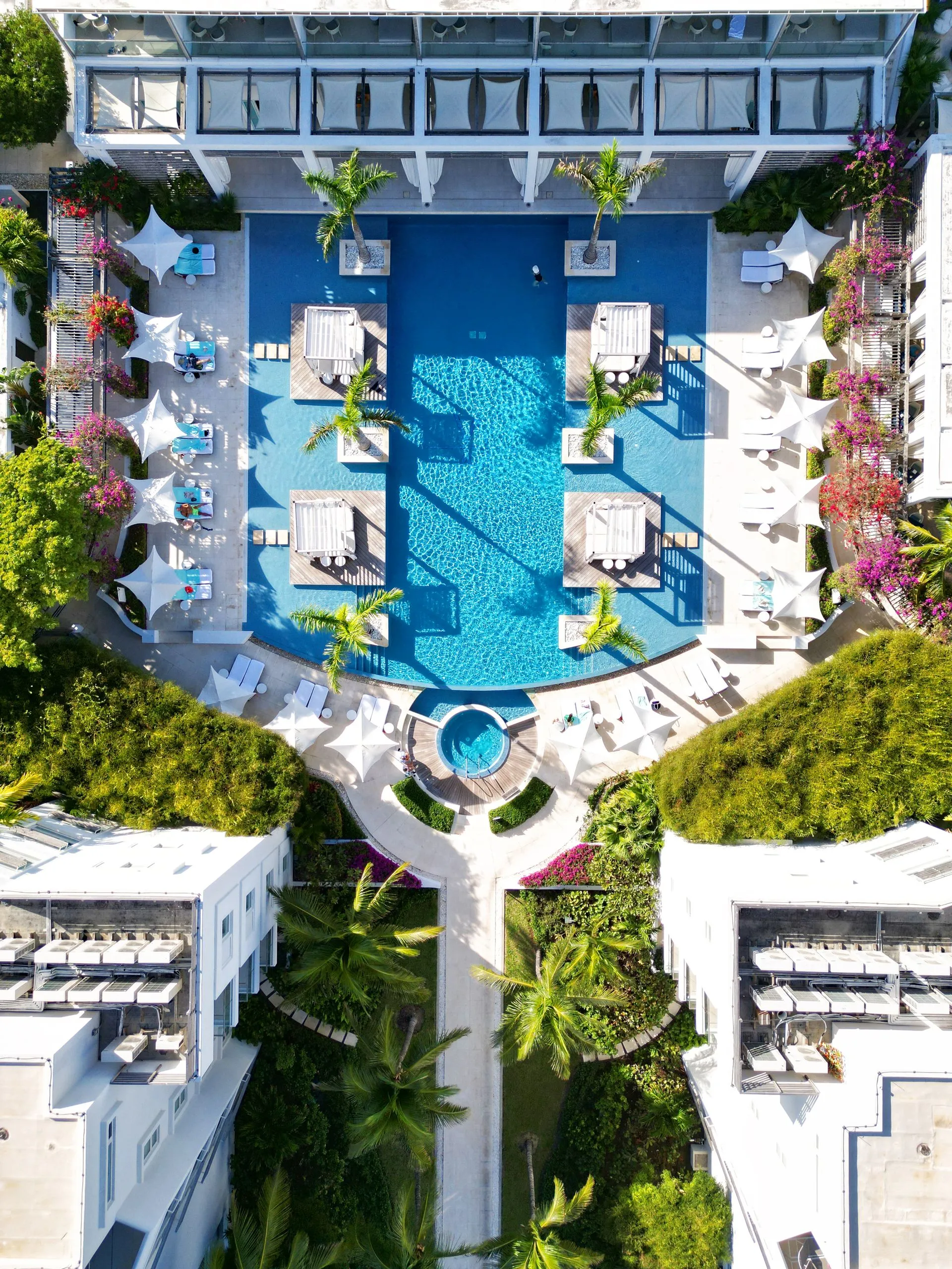 a swimming pool with white umbrellas and chairs