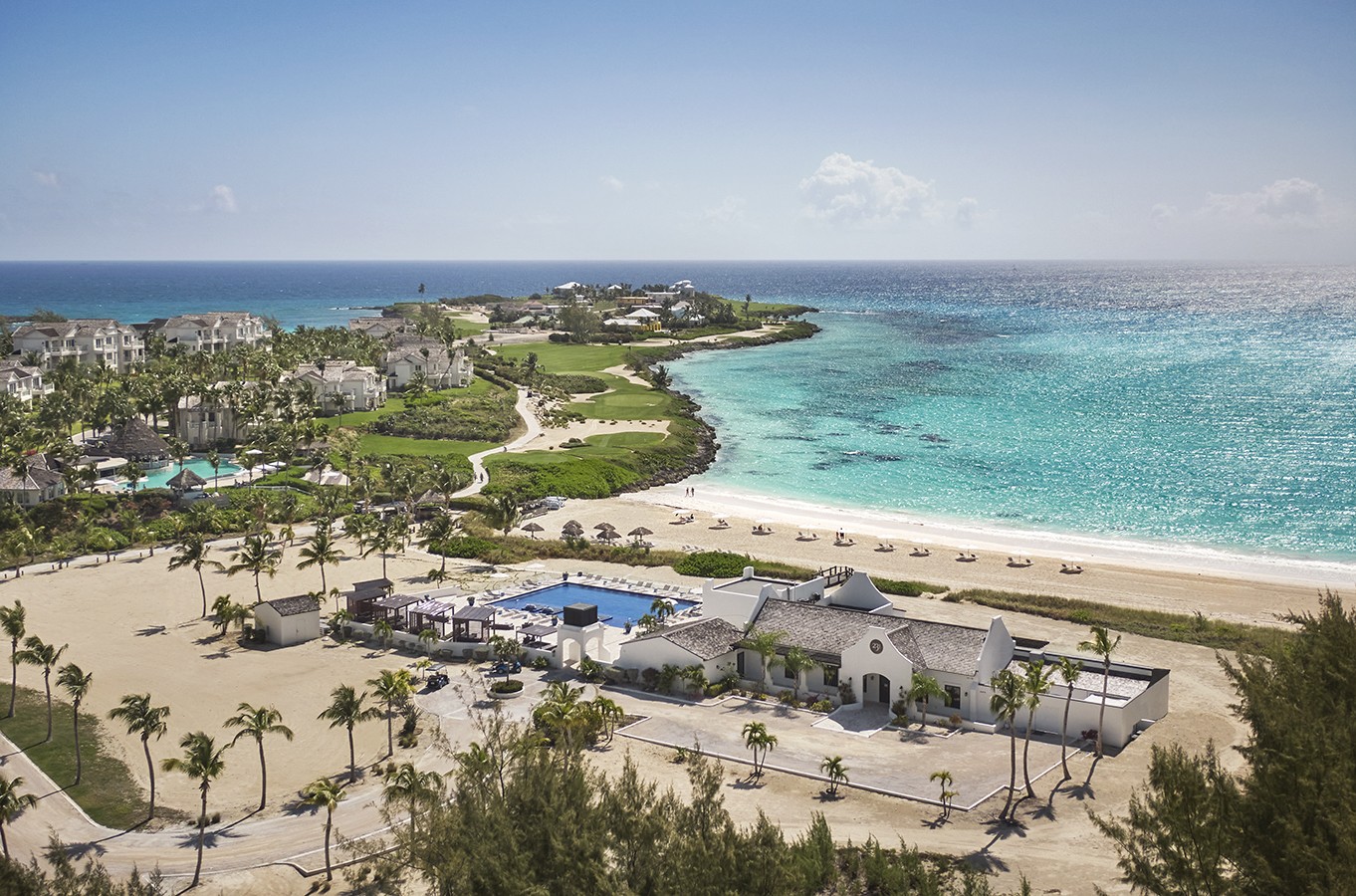a beach with buildings and a pool