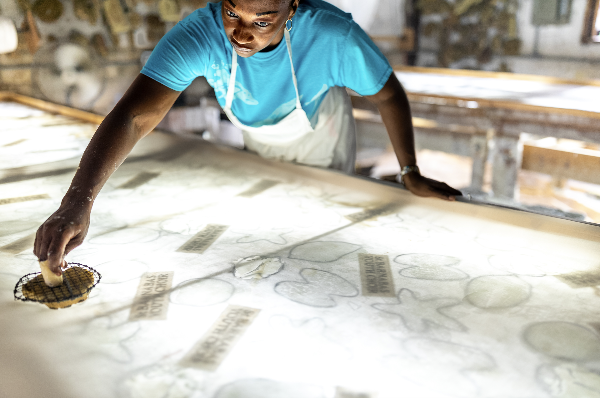 a woman in an apron looking at a table with a large screen