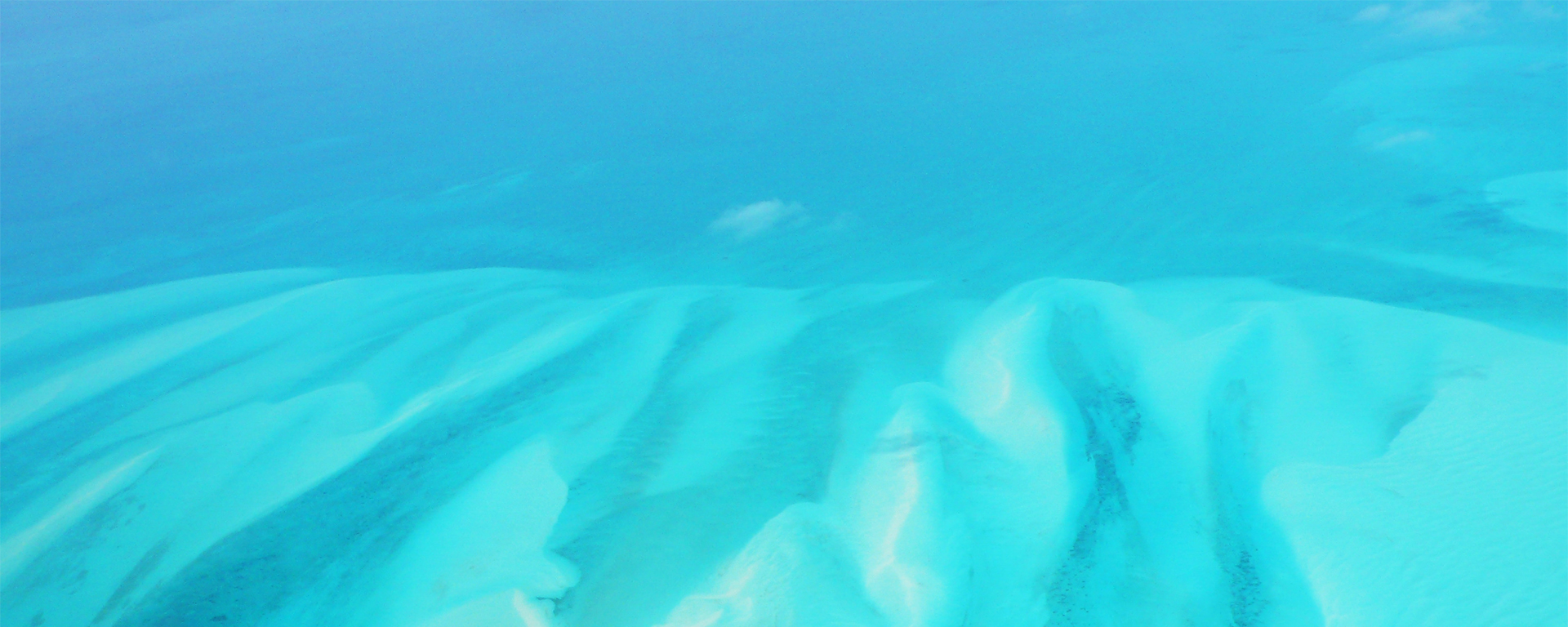 a snow covered beach with blue water