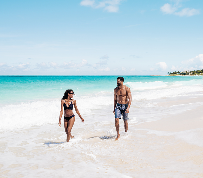 a man and woman walking on a beach