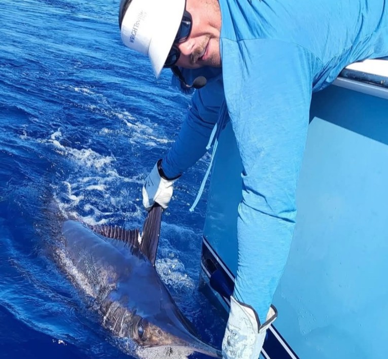 a man holding a fish in the water