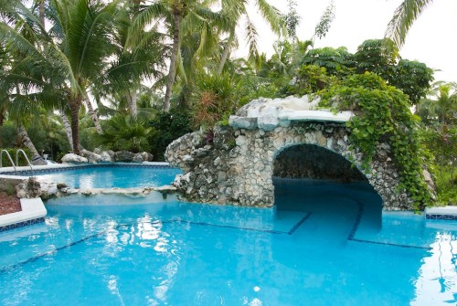 a pool with a stone arch over it