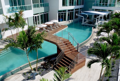 a swimming pool with a deck and umbrellas