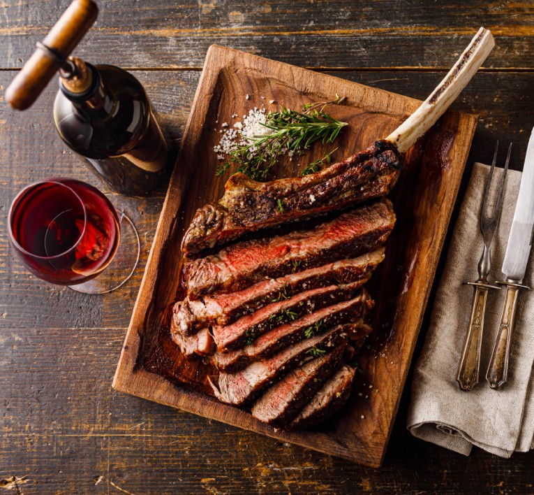 a plate of steak and wine