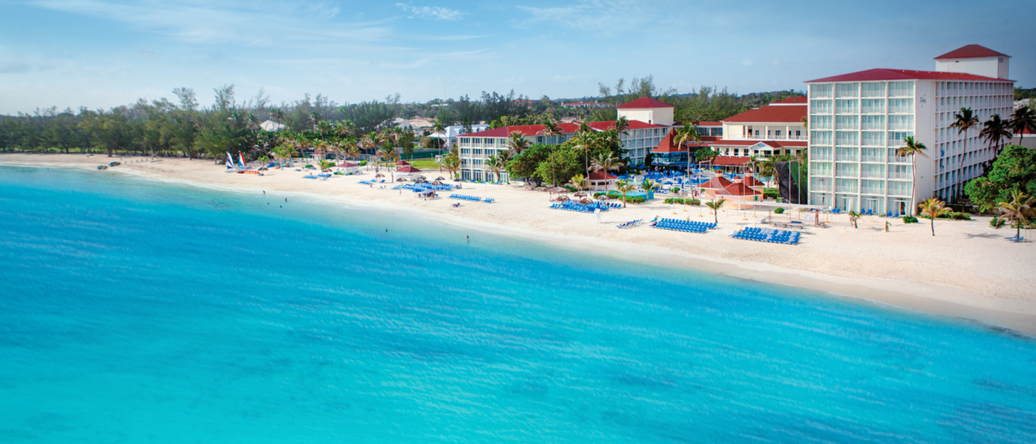 a beach with blue water and buildings