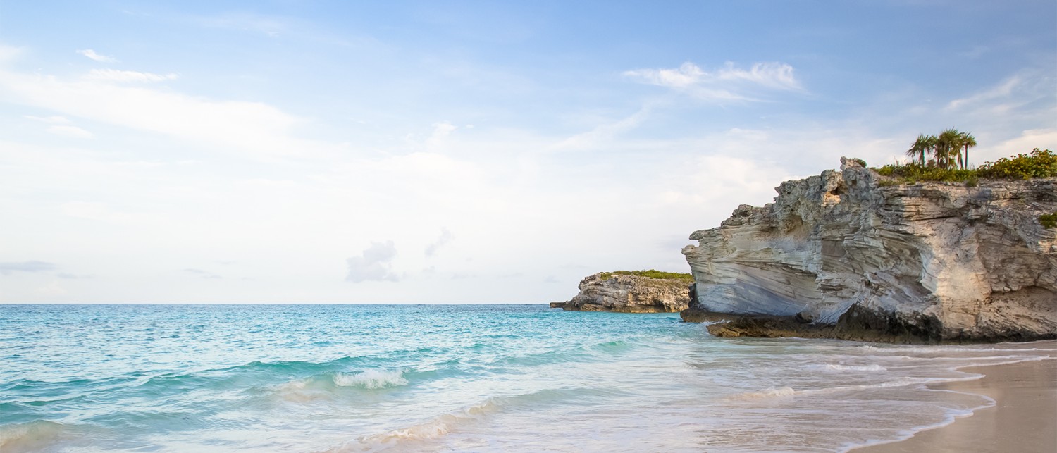 a beach with a body of water and rocks